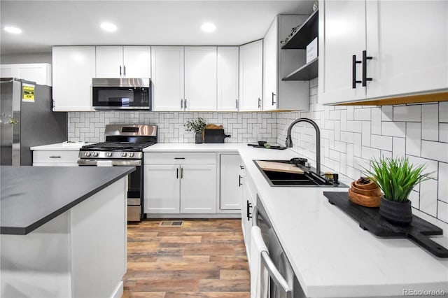 kitchen with white cabinetry, sink, stainless steel appliances, and light wood-type flooring