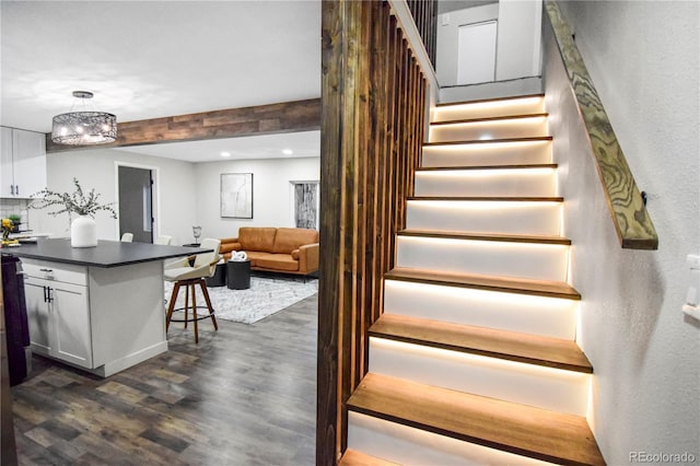 stairway with hardwood / wood-style flooring and a chandelier