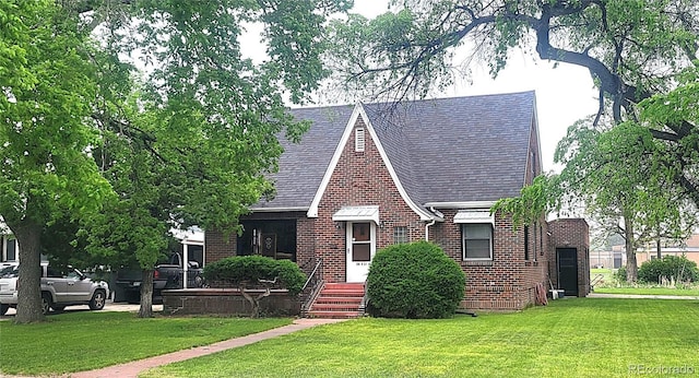 200 W 5th St, Julesburg, CO 80737 - english style home featuring brick siding, a front lawn, and roof with shingles