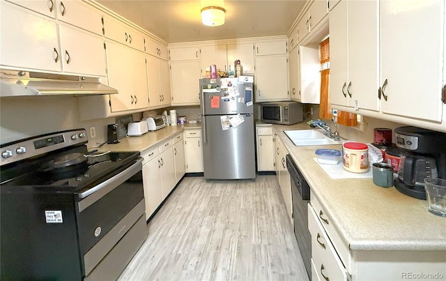 200 W 5th St, Julesburg, CO 80737 - kitchen with appliances with stainless steel finishes, under cabinet range hood, a sink, light countertops, and light wood-type flooring