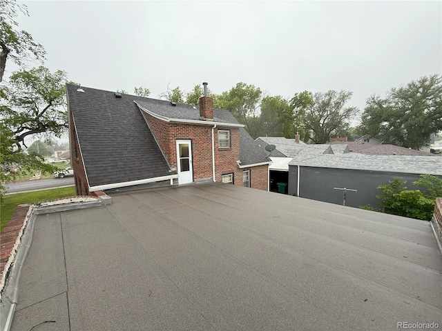 200 W 5th St, Julesburg, CO 80737 - rear view of property featuring a chimney, roof with shingles, and brick siding