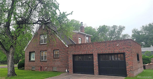 200 W 5th St, Julesburg, CO 80737 - view of home's exterior with brick siding, a garage, and a lawn