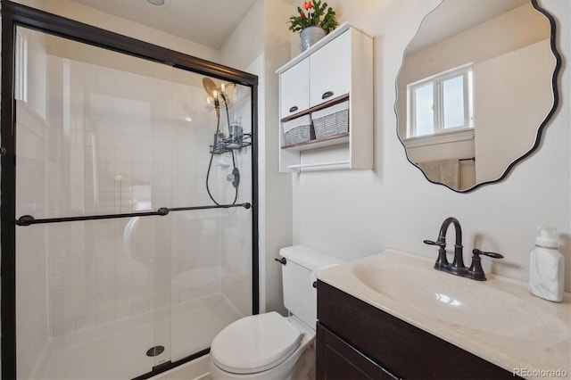 bathroom with a shower with shower door, toilet, and vanity