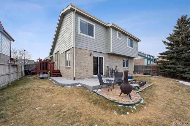 back of house with an outdoor fire pit, a yard, and a patio area