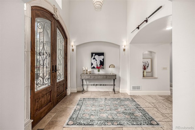648 Ruby Trust Dr, Castle Rock, CO 80108 - entryway featuring plenty of natural light, baseboards, a towering ceiling, arched walkways, and french doors
