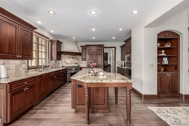 648 Ruby Trust Dr, Castle Rock, CO 80108 - kitchen featuring custom exhaust hood, a sink, appliances with stainless steel finishes, a kitchen breakfast bar, and dark wood finished floors