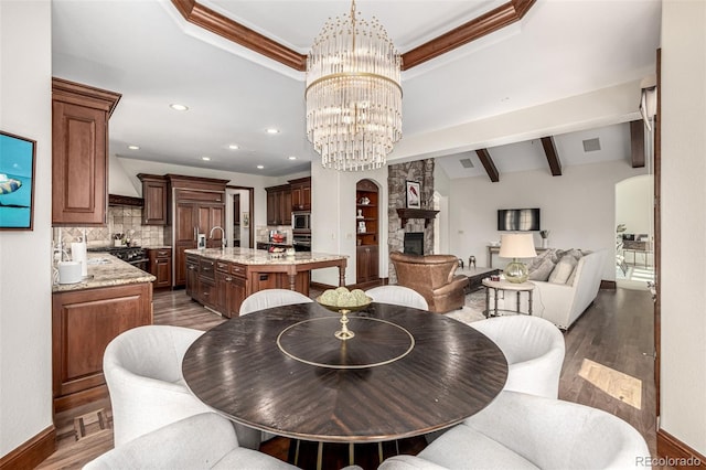 648 Ruby Trust Dr, Castle Rock, CO 80108 - dining space featuring a fireplace, a chandelier, baseboards, beam ceiling, and recessed lighting