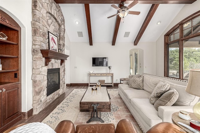 648 Ruby Trust Dr, Castle Rock, CO 80108 - living area featuring wood finished floors, a stone fireplace, arched walkways, a ceiling fan, and baseboards