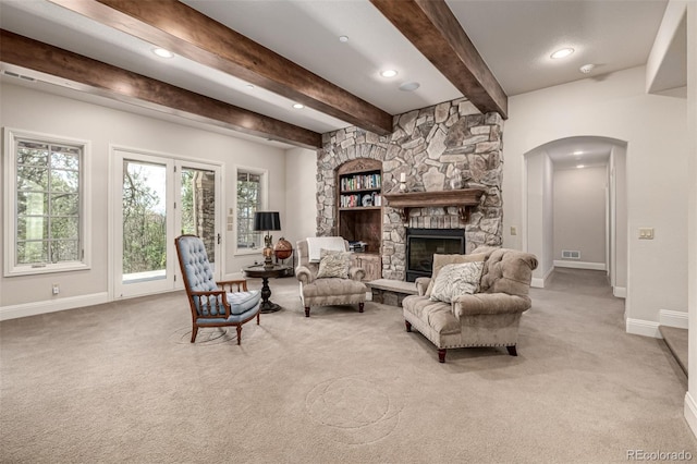 648 Ruby Trust Dr, Castle Rock, CO 80108 - carpeted living room featuring baseboards, recessed lighting, beamed ceiling, arched walkways, and a stone fireplace