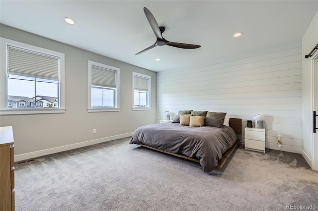 carpeted bedroom featuring recessed lighting, baseboards, wooden walls, and ceiling fan