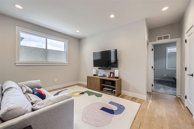 living area with light wood-style flooring, baseboards, and recessed lighting