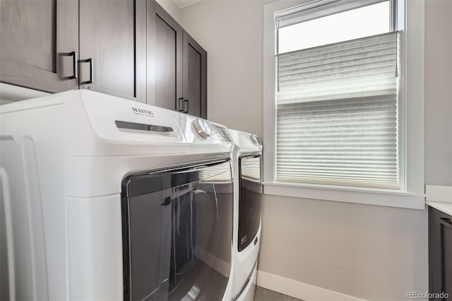 laundry room with cabinet space, washing machine and dryer, and baseboards