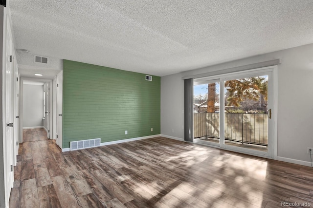 empty room featuring a textured ceiling and hardwood / wood-style flooring