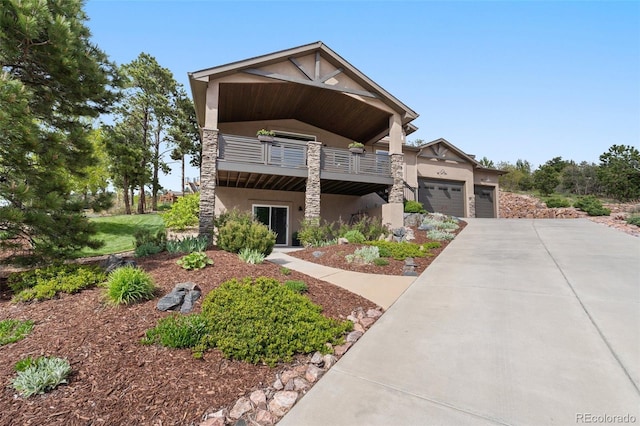 20243 High Pines Dr, Monument, CO 80132 - view of front facade with stucco siding, a balcony, driveway, a garage, and stone siding