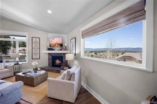 20243 High Pines Dr, Monument, CO 80132 - living area with a stone fireplace, lofted ceiling, wood finished floors, baseboards, and recessed lighting