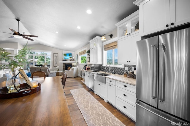 20243 High Pines Dr, Monument, CO 80132 - kitchen featuring appliances with stainless steel finishes, a ceiling fan, a sink, vaulted ceiling, and open floor plan