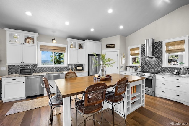 20243 High Pines Dr, Monument, CO 80132 - kitchen with appliances with stainless steel finishes, wall chimney exhaust hood, decorative backsplash, plenty of natural light, and recessed lighting