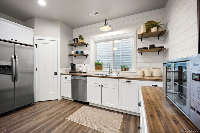 20243 High Pines Dr, Monument, CO 80132 - kitchen with stainless steel appliances, wooden counters, open shelves, a sink, and white cabinets