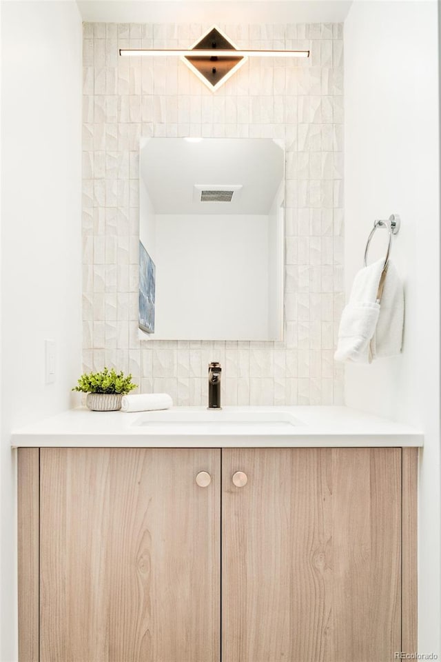 bathroom featuring vanity and decorative backsplash