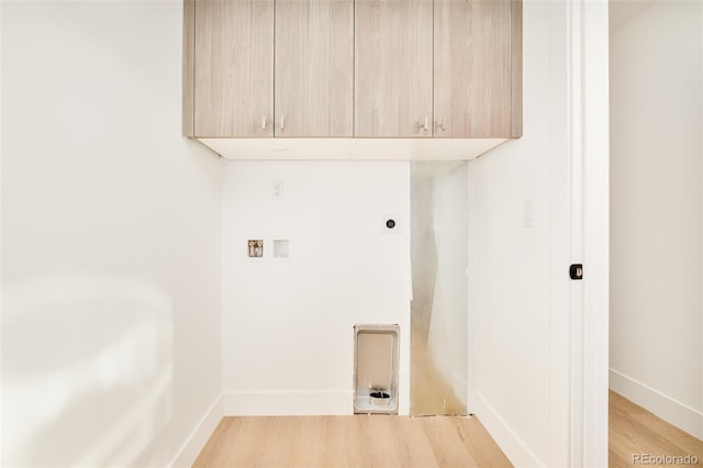 laundry room with electric dryer hookup, hookup for a washing machine, light hardwood / wood-style flooring, and cabinets