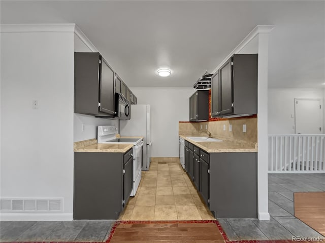 3913 Roosevelt Ave, Wellington, CO 80549 - kitchen featuring white electric stove, sink, backsplash, ornamental molding, and light tile patterned floors
