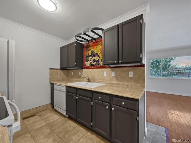 3913 Roosevelt Ave, Wellington, CO 80549 - kitchen featuring crown molding, white dishwasher, sink, and decorative backsplash