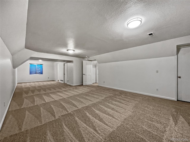 3913 Roosevelt Ave, Wellington, CO 80549 - additional living space with vaulted ceiling, a textured ceiling, and carpet flooring