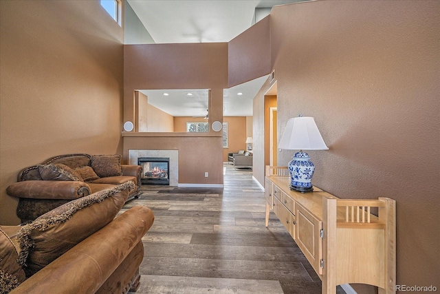 2404 S Genoa Way, Aurora, CO 80013 - living area featuring a high ceiling, dark wood-style floors, a tile fireplace, and baseboards