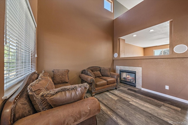 2404 S Genoa Way, Aurora, CO 80013 - living area with wood finished floors, a tile fireplace, plenty of natural light, baseboards, and a towering ceiling