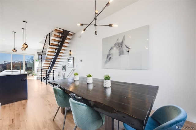 dining space with stairway, a chandelier, and light wood-style floors