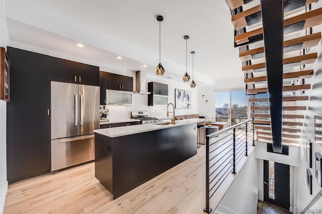 kitchen featuring wall chimney range hood, decorative light fixtures, high end refrigerator, light countertops, and range