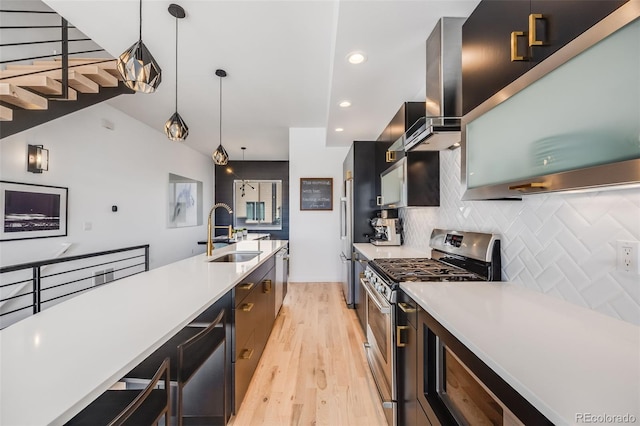 kitchen with hanging light fixtures, stainless steel appliances, a sink, and light countertops