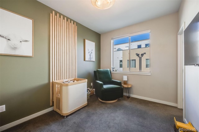 living area featuring baseboards and dark carpet