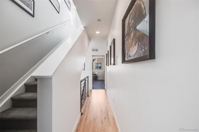 hallway featuring light wood-type flooring, recessed lighting, stairway, baseboards, and visible vents