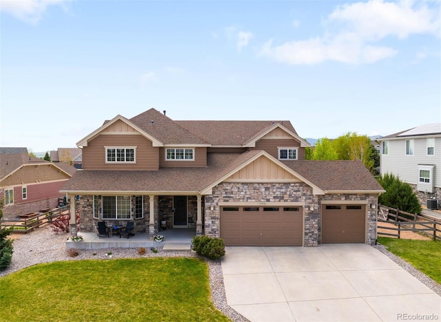17378 W 78th Dr, Arvada, CO 80007 - craftsman inspired home with an attached garage, stone siding, driveway, roof with shingles, and board and batten siding