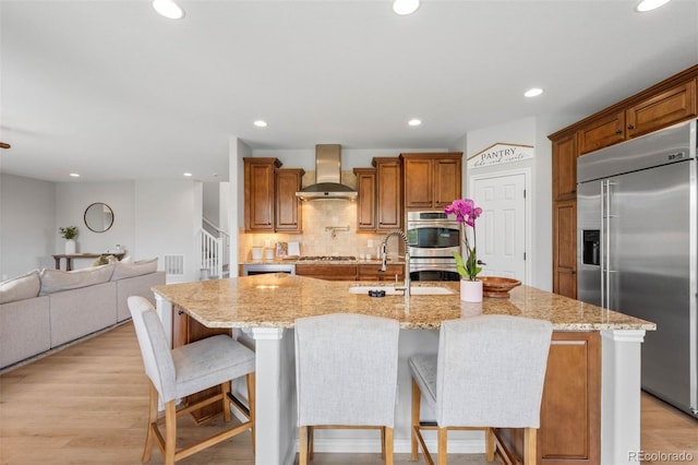 17378 W 78th Dr, Arvada, CO 80007 - kitchen featuring appliances with stainless steel finishes, wall chimney range hood, a sink, recessed lighting, and backsplash