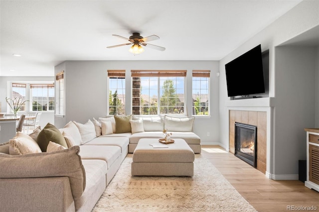 17378 W 78th Dr, Arvada, CO 80007 - living area featuring plenty of natural light, a tiled fireplace, light wood-type flooring, ceiling fan, and recessed lighting