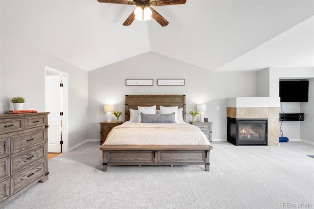17378 W 78th Dr, Arvada, CO 80007 - bedroom with light colored carpet, lofted ceiling, baseboards, a tile fireplace, and a ceiling fan