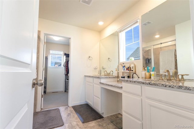 full bath featuring a stall shower, visible vents, a spacious closet, and vanity