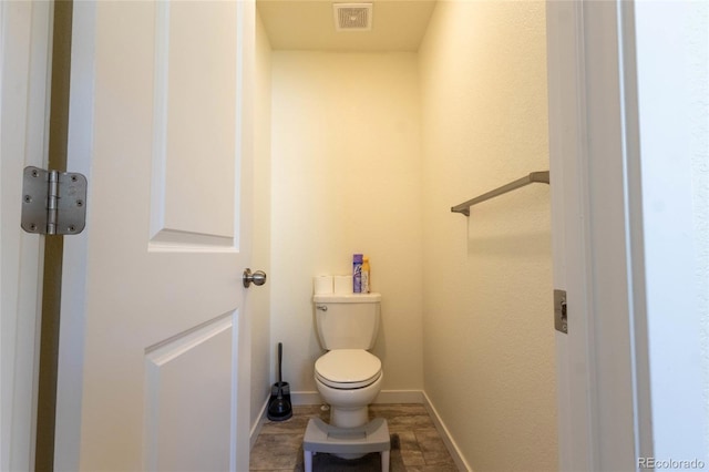 bathroom with toilet, baseboards, and visible vents