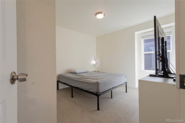 bedroom featuring baseboards and light colored carpet