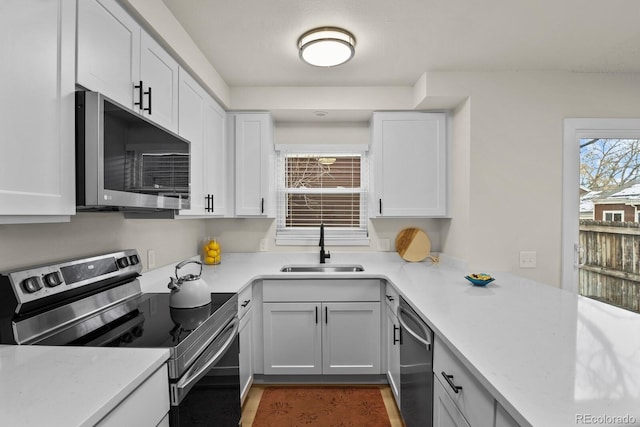 kitchen featuring white cabinetry, stainless steel appliances, sink, and light stone counters