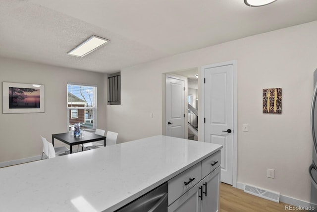 kitchen with a textured ceiling and light hardwood / wood-style flooring