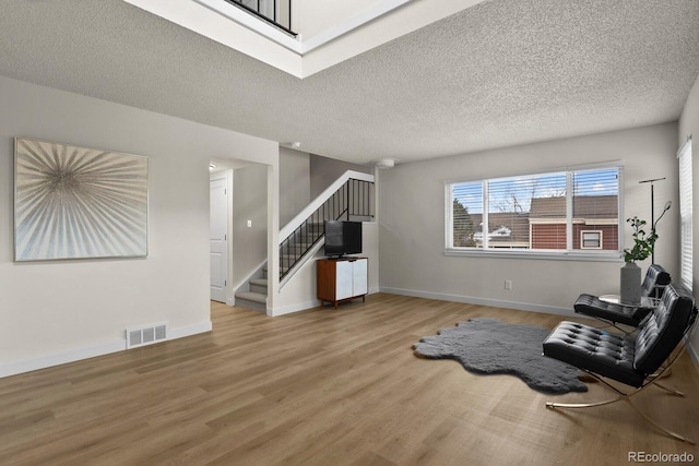 sitting room featuring wood-type flooring and a textured ceiling