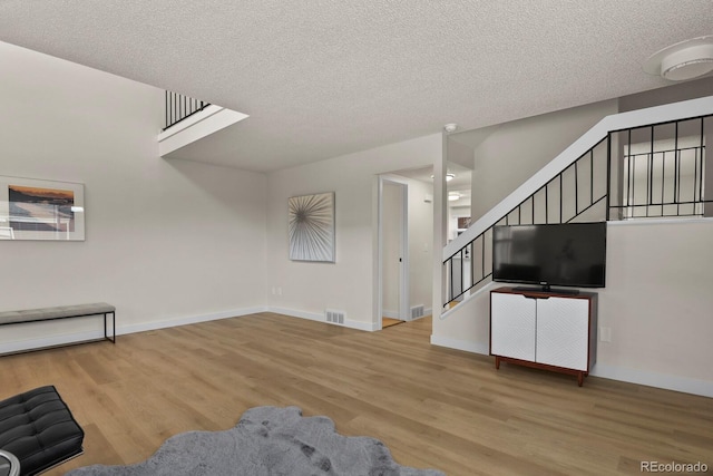 living room featuring a textured ceiling and light hardwood / wood-style flooring