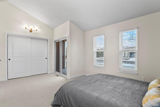 carpeted bedroom featuring lofted ceiling, a closet, and a textured ceiling