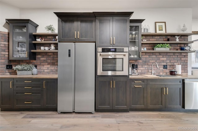 kitchen featuring stainless steel appliances, light hardwood / wood-style floors, and tasteful backsplash