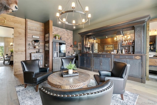 interior space with a notable chandelier, light hardwood / wood-style flooring, and wooden walls