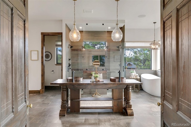 bathroom featuring independent shower and bath and a chandelier