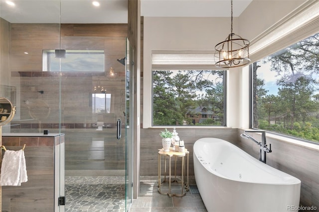 bathroom featuring an inviting chandelier and plus walk in shower